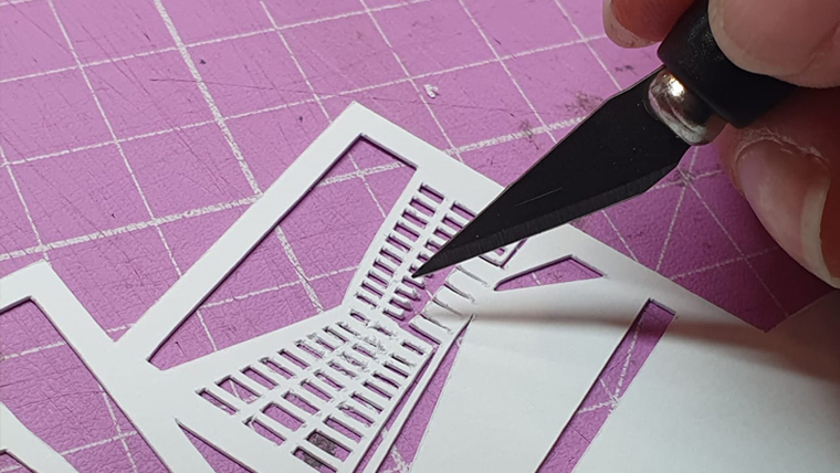 Artisan d’art travaillant une création en papier dans son atelier