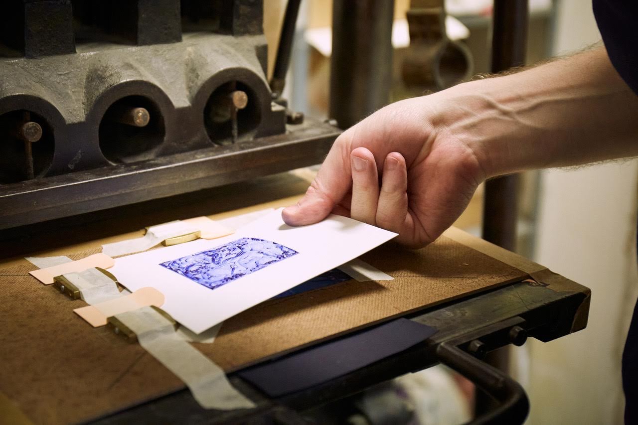 Tirage d'une gravure bleue sur une presse d'atelier