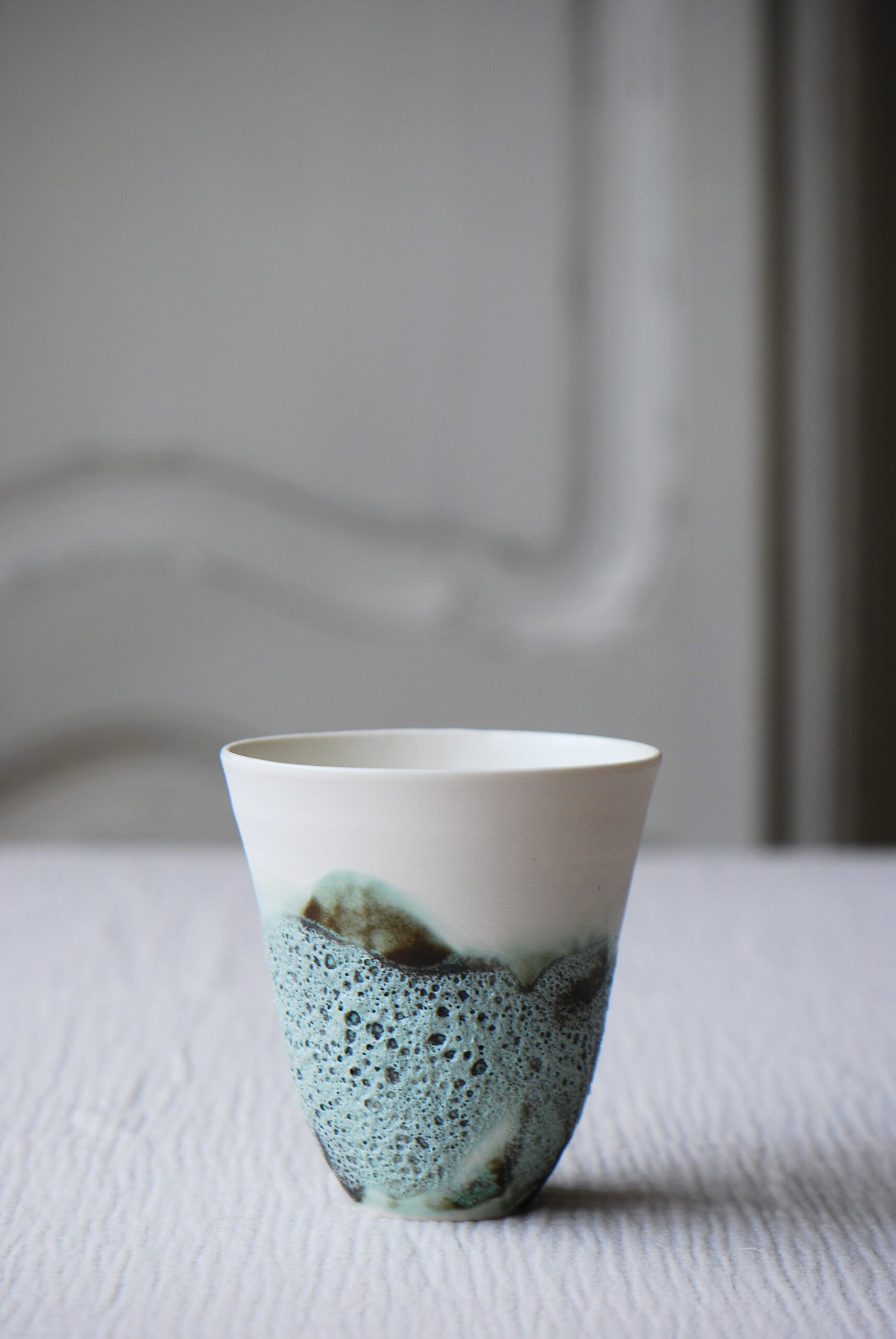 Une tasse en céramique texturée ave des touches colorées